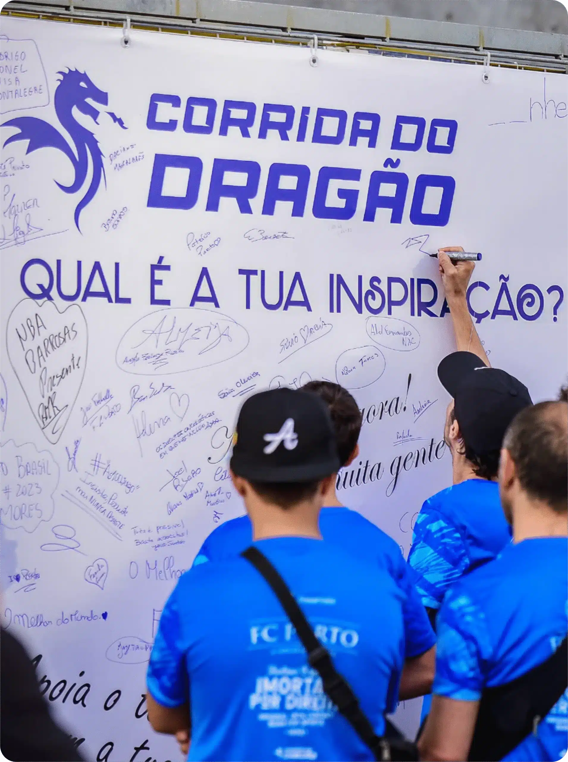 Pessoas escrevendo em um mural da Corrida do Dragão.